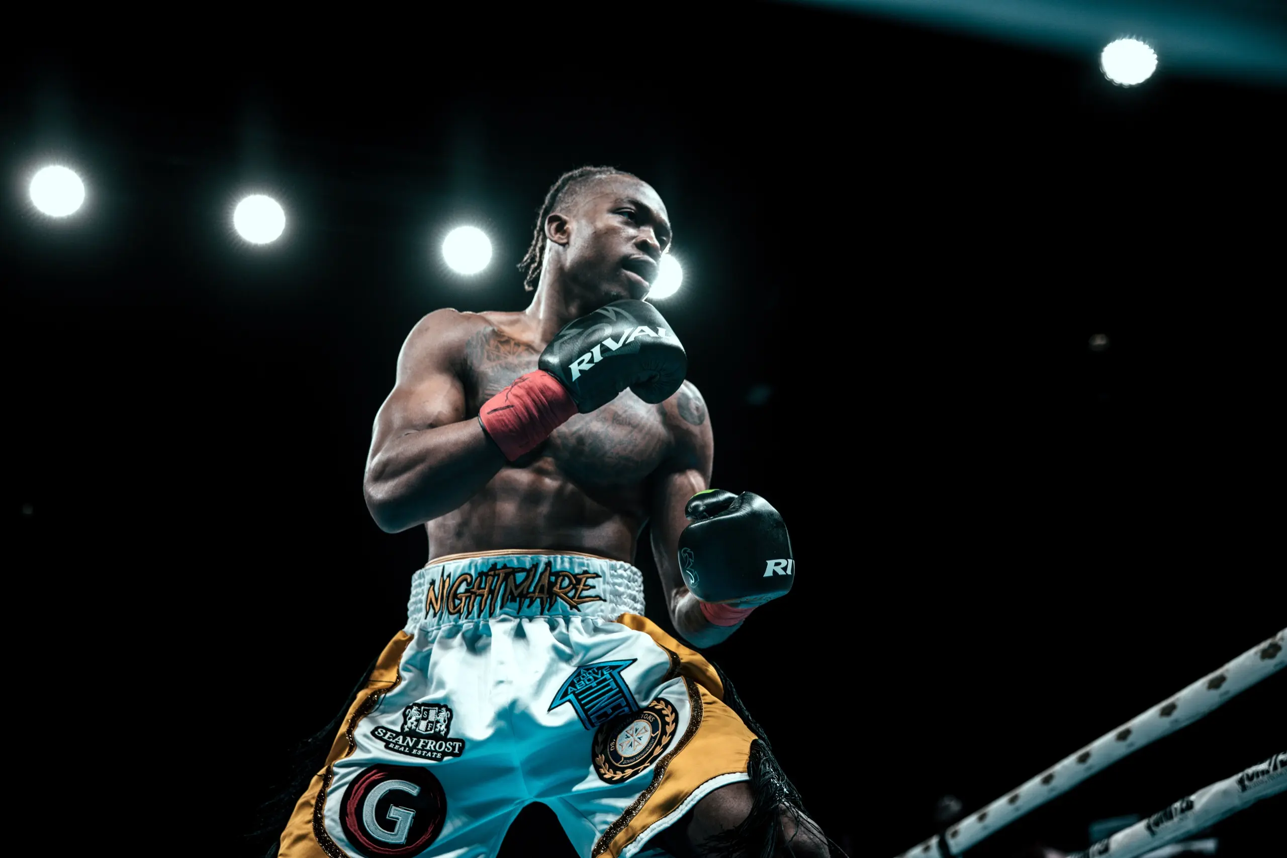 Mccainly Thomas stands mid-ring with his gloves crossed under the arena lights